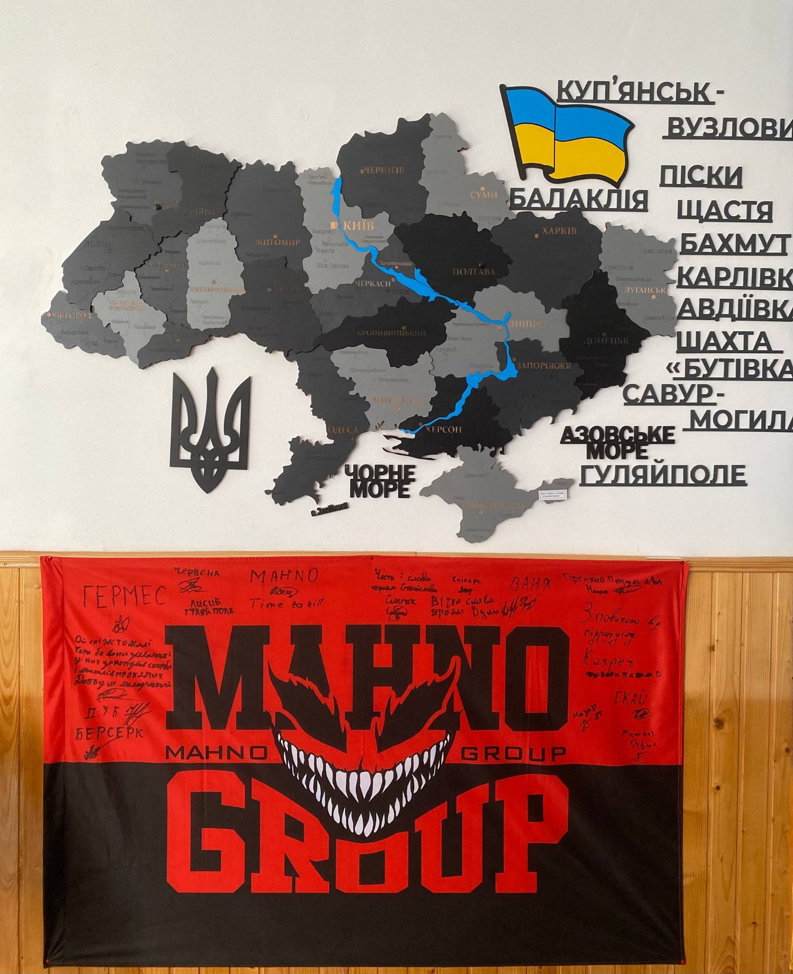 Карта України та прапор підрозділу «Mahno Group» з підписами побратимів